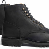 Meermin black waxy commander Service boot, close-up on lace eyelets and cleated rubber sole, heel-to-toe angle